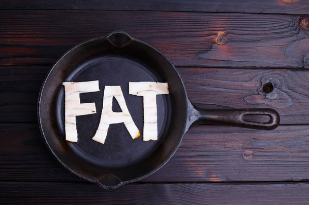 Bacon shaped as the word Fat in the frying pan. Diet, nutrition, - Fotoğraf, Görsel