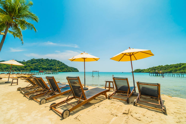 Parapluie et chaise sur la belle plage tropicale et la mer avec cocotier dans l'île paradisiaque pour les voyages et les vacances
 - Photo, image