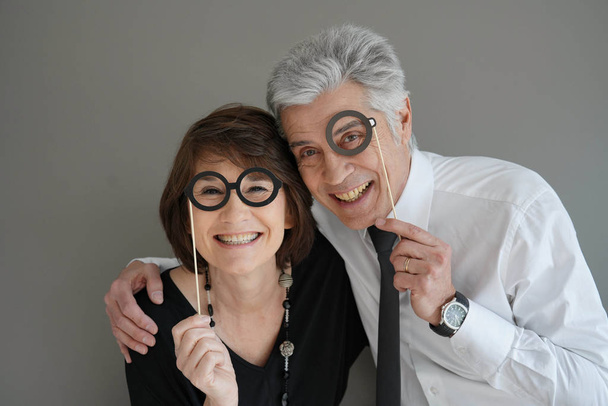 Cheerful senior couple with photobooth props, isolated - Fotografie, Obrázek