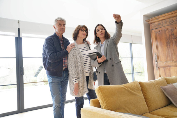 Senior couple with real estate agent visiting contemporary house - Fotoğraf, Görsel