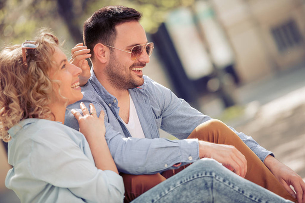 Jovem casal feliz se divertindo ao ar livre e sorrindo. Pessoas, amor, felicidade e estilo de vida conceito
. - Foto, Imagem