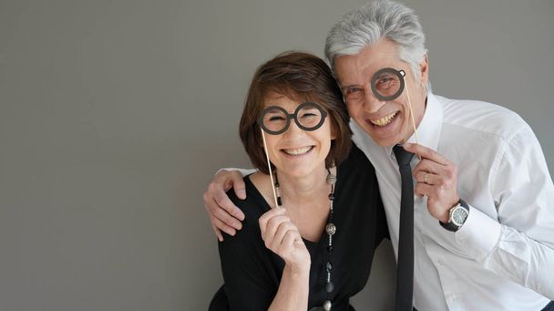 Cheerful senior couple with photobooth props, isolated - Foto, immagini
