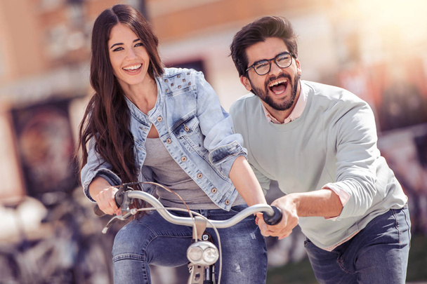 Couple chevauchant leurs vélos dans leur temps libre et s'amusant sur une journée d'été ensoleillée
. - Photo, image