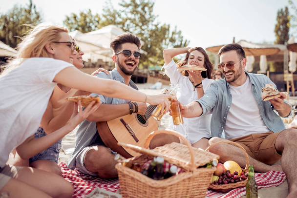 Skupina happy mladých lidí mít piknik na pláži - Fotografie, Obrázek