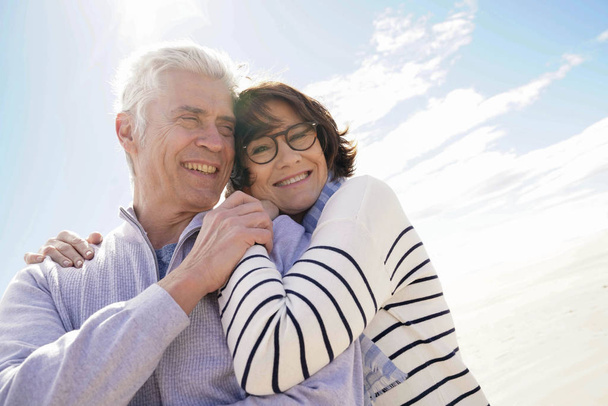 Portrait of senior couple embracing by the beach - Photo, image