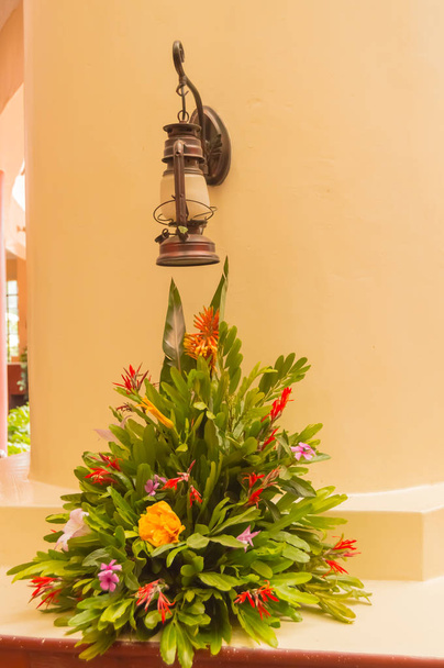 Montage d'un bouquet de fleurs sous une vieille lanterne pose sur un w
 - Photo, image