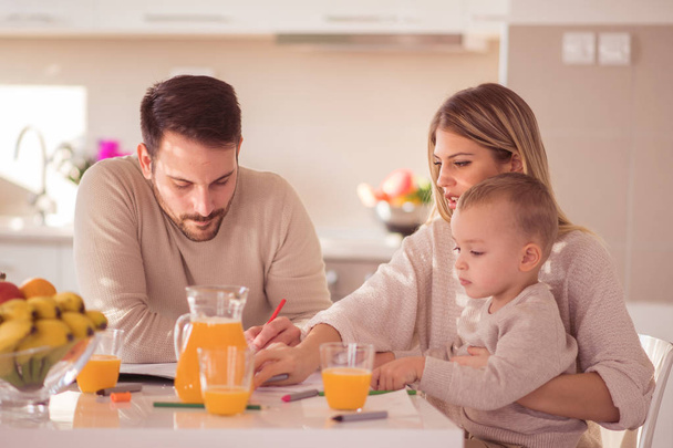 Happy family making orange juice in their kitchen.Family,love,happiness,food and drink concept. - Photo, Image