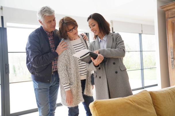 Senior couple with real estate agent visiting contemporary house - Photo, image