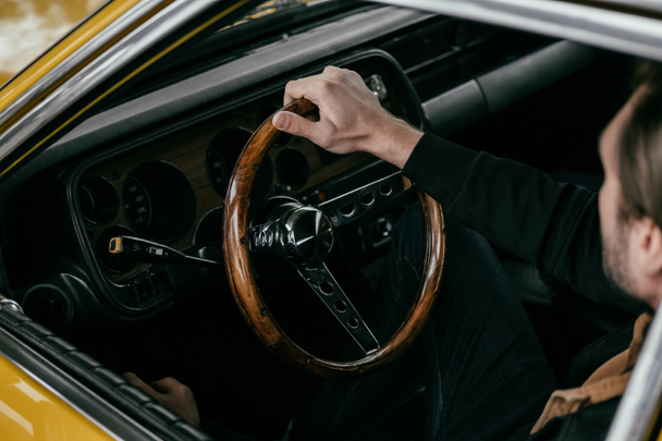 visão de alto ângulo do homem segurando o volante do automóvel antiquado
 - Foto, Imagem