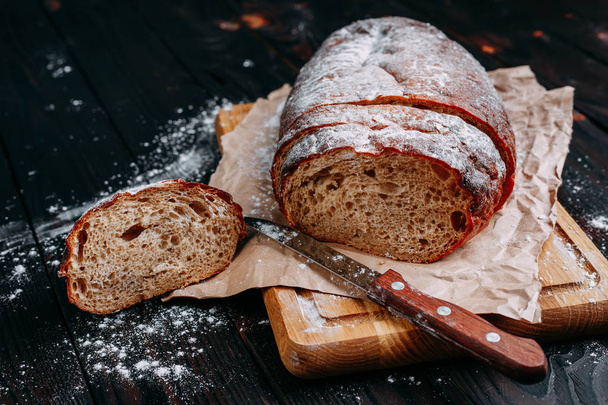 Freshly baked sliced rye bread on wooden cutting board - Foto, Imagen