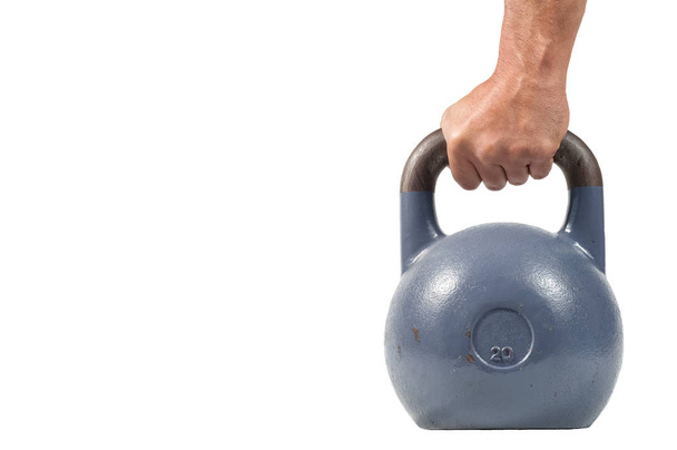 Strong muscular man hand with muscles holding heavy kettlebell partially isolated on white background - Photo, Image
