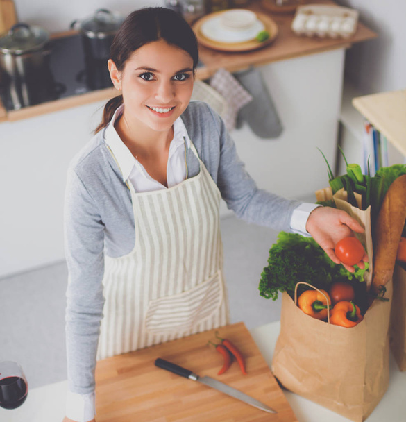 Woman making healthy food standing smiling in kitchen - Valokuva, kuva