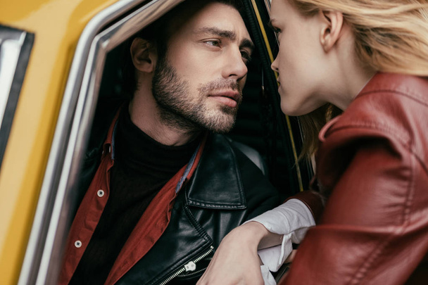 stylish young couple in love looking at each other through car window - Фото, зображення