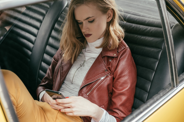 high angle view of girl using smartphone in vintage car - Photo, Image