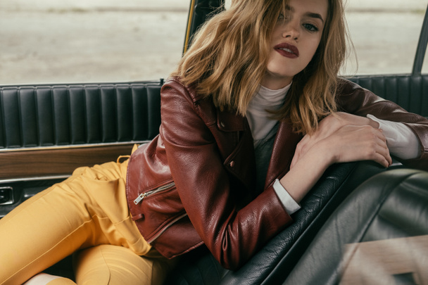 güzel bir baştan çıkarıcı genç kadın arabada otururken kameraya bakıyor   - Fotoğraf, Görsel