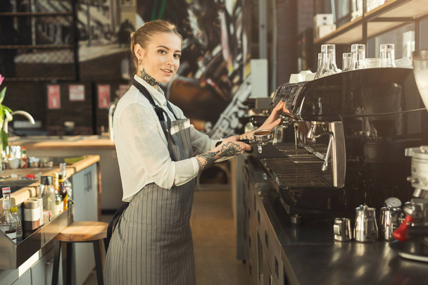 Wytatuowany barista parzenia kawy w profesjonalny ekspres do kawy - Zdjęcie, obraz