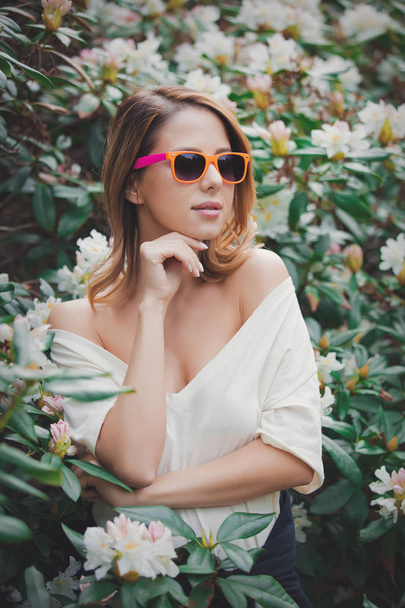 girl in white sunglasses near flowers - Zdjęcie, obraz