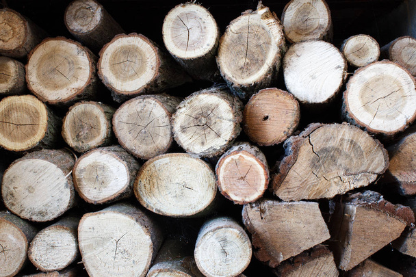Achtergrond van droog gehakt brandhout houtblokken opgestapeld op elkaar in een stapel - Foto, afbeelding