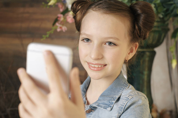 personas, niños y el concepto de la tecnología - chica con ordenador portátil y teléfono inteligente tomar selfie o tener videollamada en casa - Foto, imagen