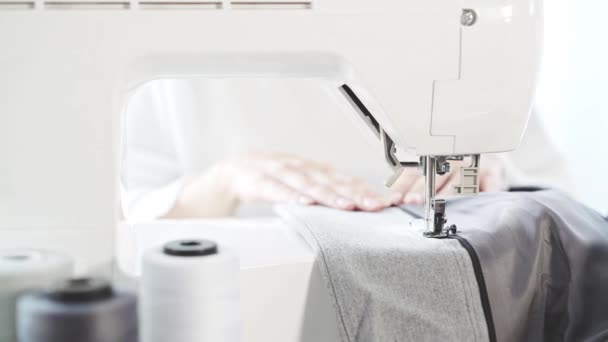 Unrecognizable young woman s hands sewing a jacket at a sewing machine, business - Materiał filmowy, wideo