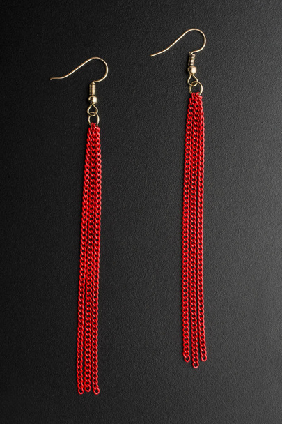 серьги с красными цепями изолированы на черном
 - Фото, изображение