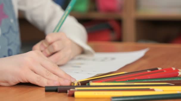 Little girl draws the pictures using color pencils - Felvétel, videó
