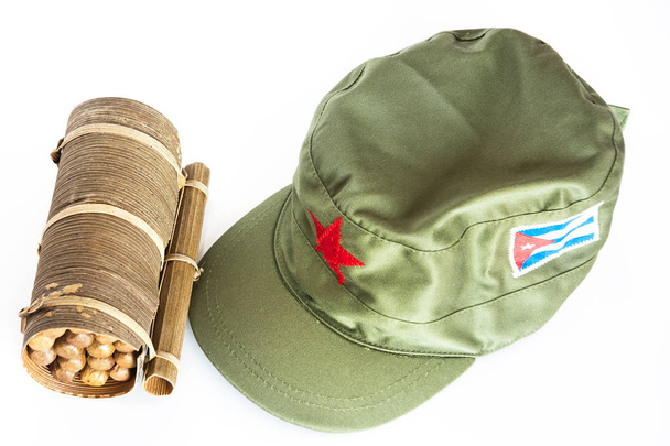 Some Cuban cigars rolled in banana leaf and military cap with red star  and cuban flag - Photo, Image