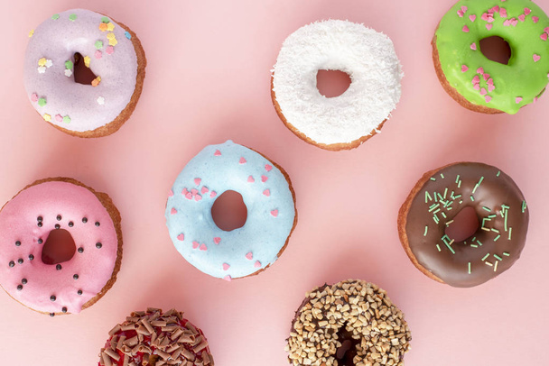 Set of donuts covered with glaze on pink background - Foto, afbeelding