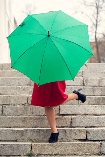 La chica detrás de un paraguas
 - Foto, imagen