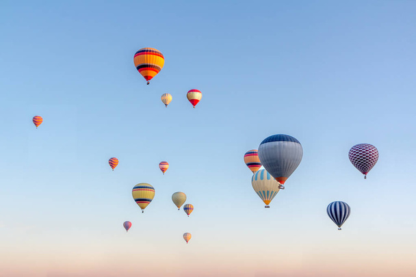 helle bunte Heißluftballons fliegen in den Sonnenaufgangshimmel - Foto, Bild