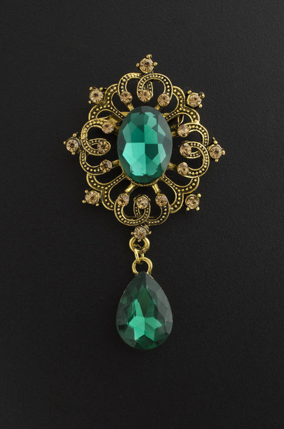 golden vintage brooch with emeralds isolated on black - Photo, Image