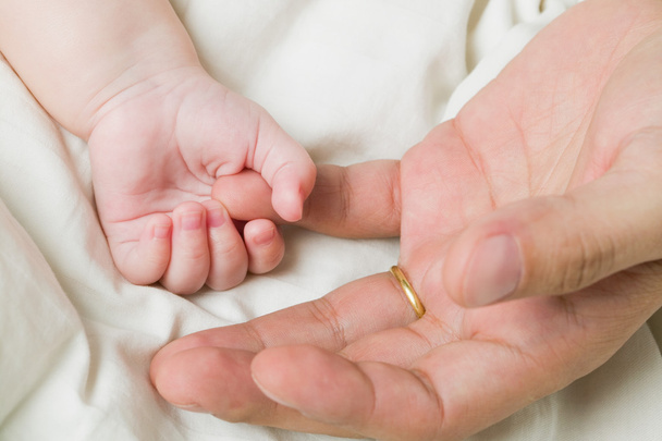 Bebek el bir adamın elini tutarak - Fotoğraf, Görsel