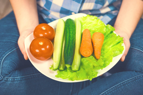 Menina com um prato de legumes
 - Foto, Imagem