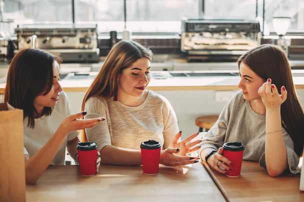 Group of three friends having fun a coffee together. Young women - Photo, image