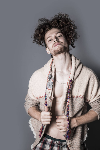 Attractive young man with long ginger curly hair posing with athletic body in pajamas and cardigan, studio portrait - Fotoğraf, Görsel