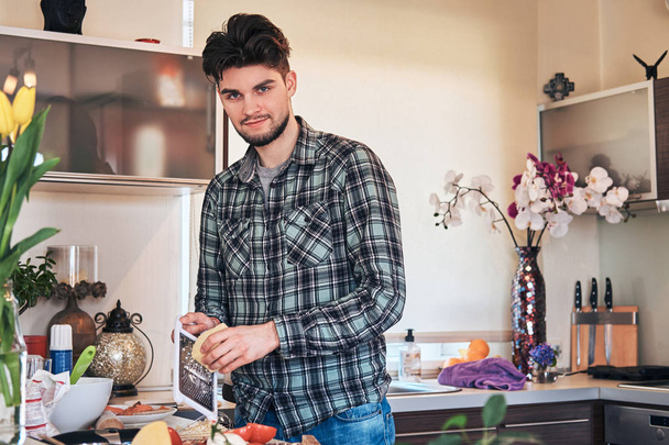 Handsome stylish guy preparing food in the kitchen at home. - Foto, Imagem