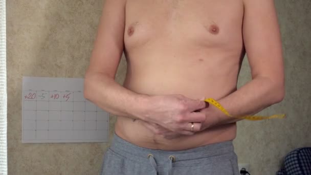 Жирний чоловік вимірює свою талію, великий пивний живіт, здоровий спосіб життя підбирає жирні складки
 - Кадри, відео