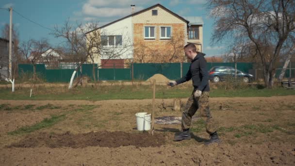 мужчина копает землю сапогом - Кадры, видео