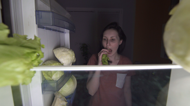 tyytymätön tyttö dieetillä syö salaattia yöllä, nälkä
 - Materiaali, video