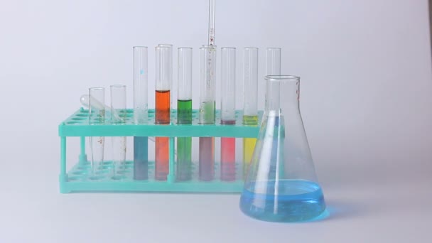 Lombikok laboratóriumi és poharak az asztalon - Felvétel, videó