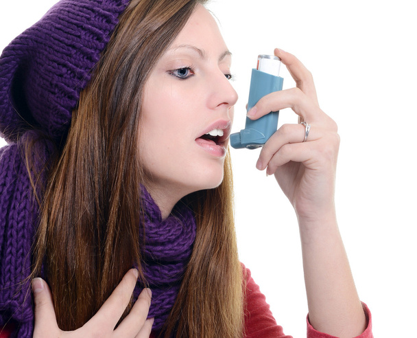 Woman with asthma using an asthma inhaler - 写真・画像