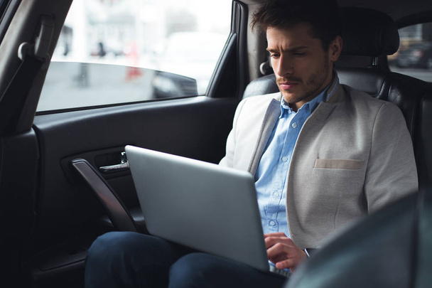 Make money easily! Smart awesome acknowledged man while sitting in the car, using his wireless computer and making his own business. - 写真・画像