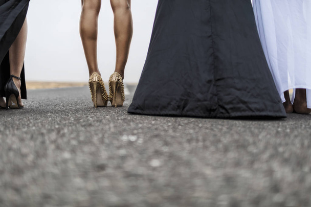 Pernas de mulher na estrada de asfalto com sapatos de moda
. - Foto, Imagem