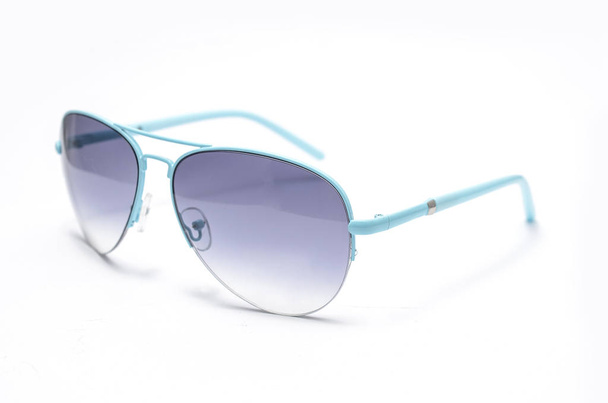 Сонцезахисні окуляри з блакитним склом в залізній рамці ізольовані на білому
 - Фото, зображення