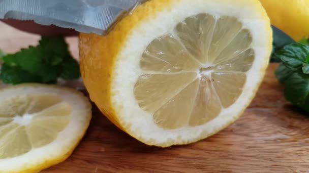 knife slices a lemon on a wooden slow-motion shot - Footage, Video