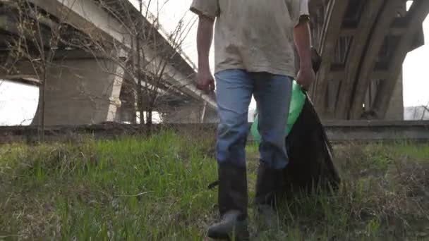 Az ember séta a közeli lábak szemetet táskák - Felvétel, videó