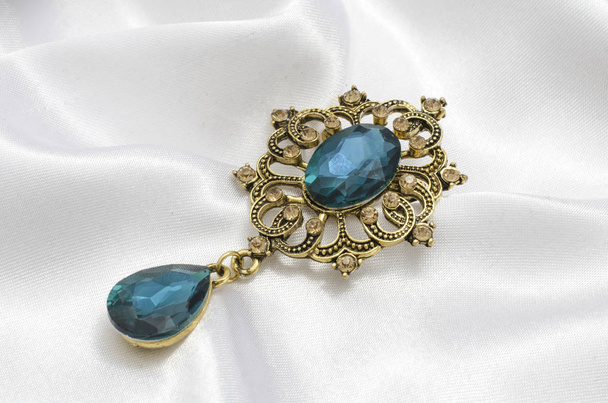 zlaté vintage brož s modrým kamenem na hedvábí - Fotografie, Obrázek