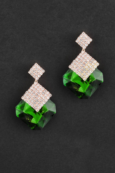 gold earrings with big green stones isolated on black - Photo, Image