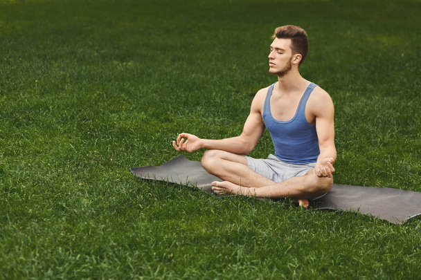 Young man practicing yoga, relax meditation pose - 写真・画像
