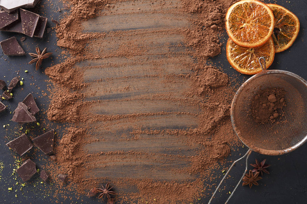 Polvo de cacao aromático esparcido sobre fondo negro
 - Foto, Imagen